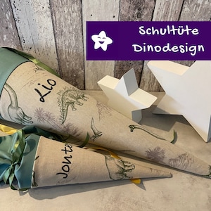 Cono escolar de tela bordado con nombre y motivo de dinosaurio en color beige y verde antiguo.