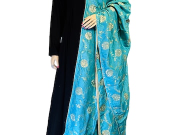 Op de afbeelding: Een zwarte maxi-jurk met lange mouwen en een turquoise dupatta met gouden bloemenborduurwerk. De dupatta heeft een gouden rand.