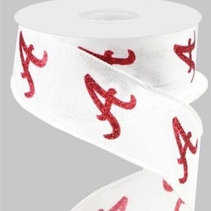 May include: White ribbon with red glitter "A" letters printed on it. The ribbon is rolled up on a spool.