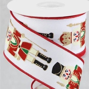 May include: A roll of white ribbon with a red trim, featuring a repeating pattern of toy nutcracker soldiers in red, green, black, and gold. The ribbon is ideal for holiday crafts and decorations.