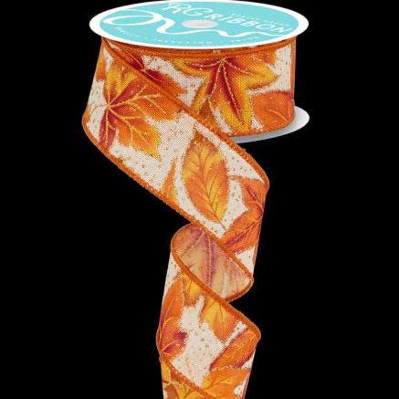 May include: Orange and yellow leaf patterned ribbon with a white background and a subtle shimmer. The ribbon is 2.5 inches wide.