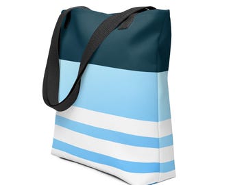 Puede incluir: Una bolsa de tela azul y blanca a rayas con asas negras. La bolsa tiene una franja azul oscuro en la parte superior.