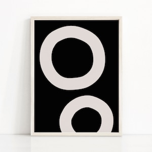 Puede incluir: Impresi&oacute;n de arte abstracto con dos c&iacute;rculos superpuestos en color gris claro sobre un fondo negro. La impresi&oacute;n est&aacute; enmarcada en un marco blanco.