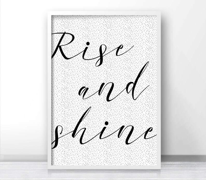 May include: Black and white printable wall art with a white background and black polka dots. The text "Rise and shine" is written in a cursive font.