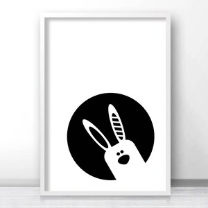 May include: Black and white illustration of a bunny rabbit's face peeking out from a circle.