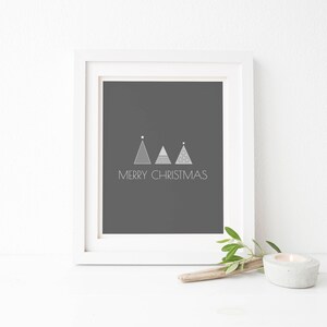 May include: A white frame with a black background and the text "Merry Christmas" in white. Three stylized silver Christmas trees are above the text.