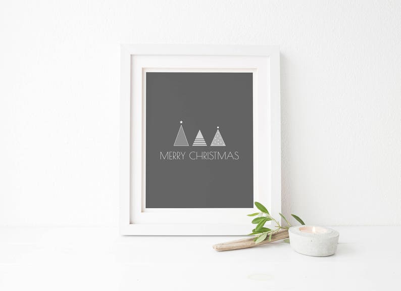 May include: A white frame with a black background and the text "Merry Christmas" in white. Three stylized silver Christmas trees are above the text.