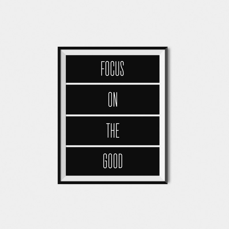 Op de afbeelding: Zwart-wit ingelijste print met de tekst "FOCUS ON THE GOOD" in een minimalistische stijl.