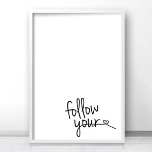 May include: A white framed print with the text "follow your" in black cursive writing with a small heart symbol at the end of the text.