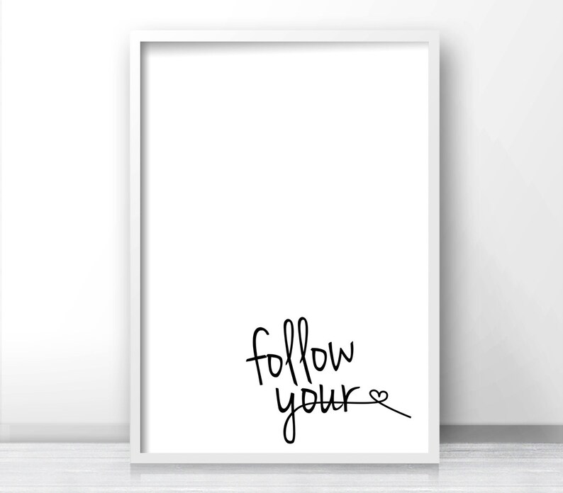 May include: A white framed print with the text "follow your" in black cursive writing with a small heart symbol at the end of the text.