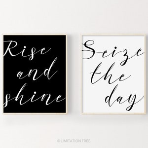 May include: Two black and white printable wall art prints with motivational quotes. The left print has the text "Rise and shine" in white script on a black background. The right print has the text "Seize the day" in black script on a white background.