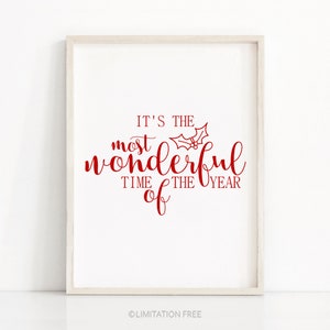 Peut inclure: Une impression encadrée blanche avec du texte rouge qui dit "C'est le moment le plus merveilleux de l'année" avec un graphique de brin de houx.