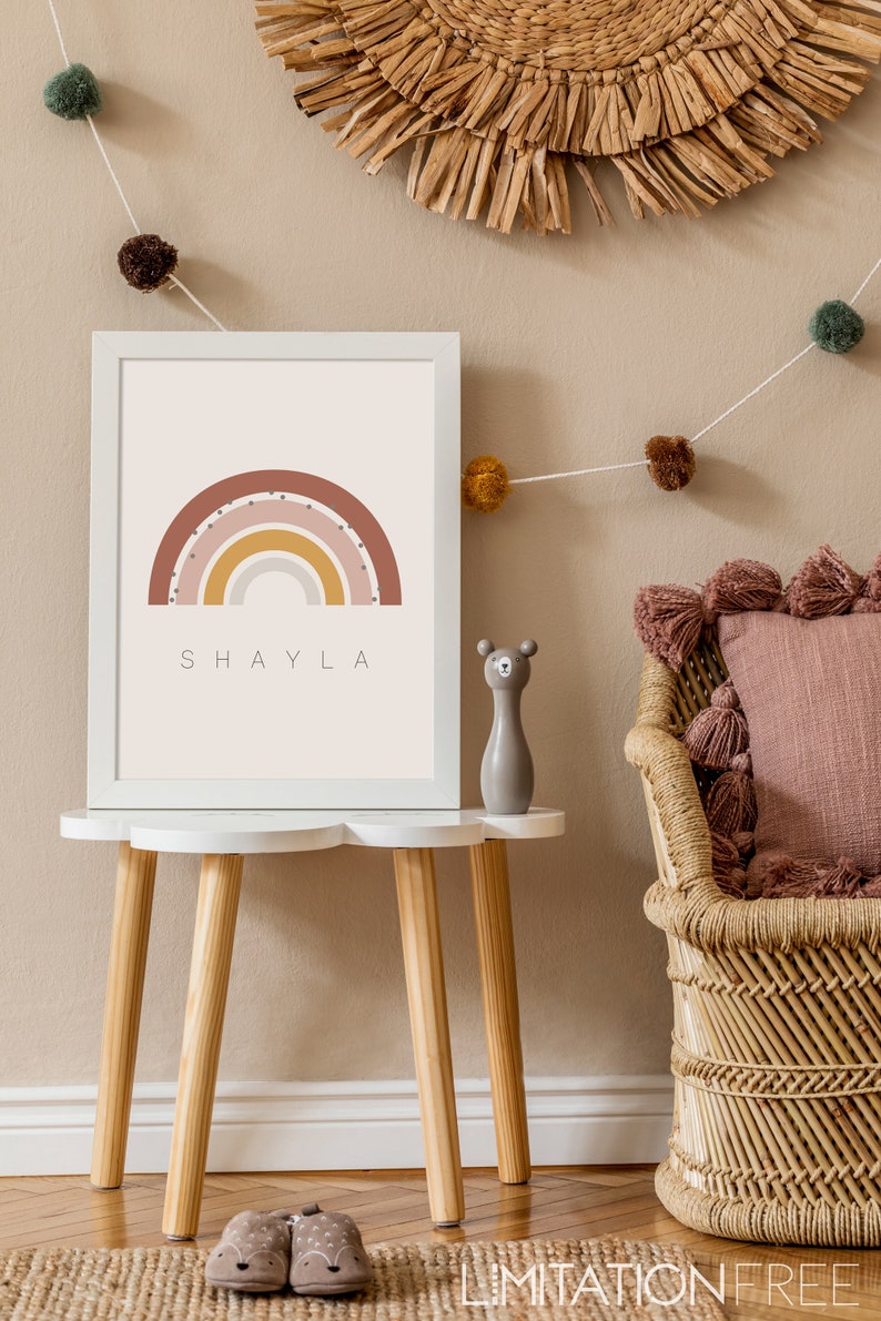 May include: A white framed print with a rainbow design in shades of pink, yellow, and orange. The rainbow has white polka dots and the name "SHAYLA" is printed below it.