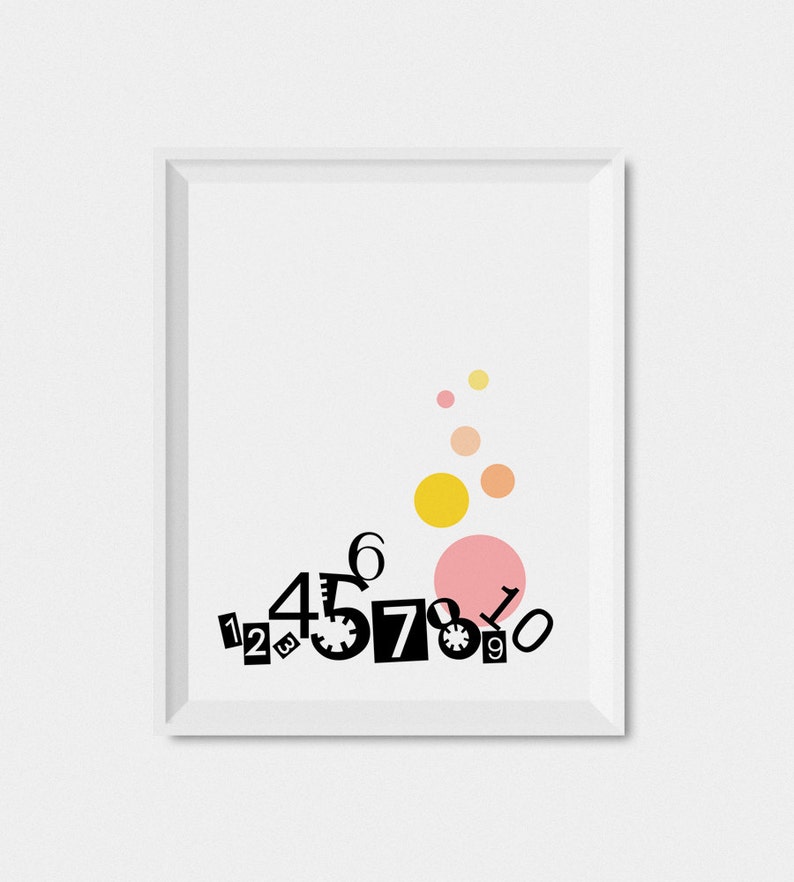 May include: A white framed print with black numbers 1 through 10 arranged in a cluster at the bottom. The numbers are in different sizes and styles. There are five yellow and pink circles in the upper half of the print.