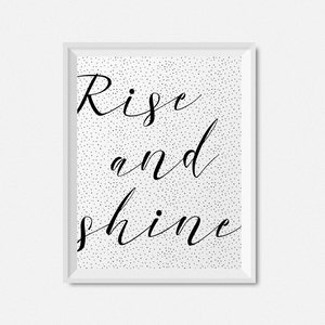 May include: Black and white printable wall art with a white background and black polka dots. The text "Rise and shine" is written in a cursive font.