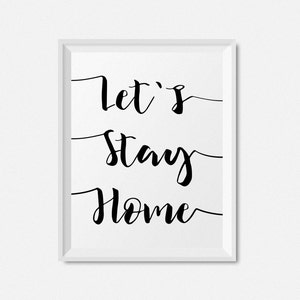 Może przedstawiać: Biały wydruk w ramie z czarną kaligrafią, kt&oacute;ra brzmi "Let's Stay Home".