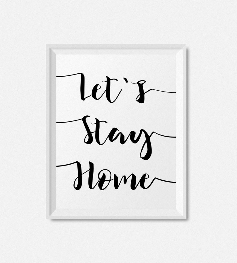 Może przedstawiać: Biały wydruk w ramie z czarną kaligrafią, kt&oacute;ra brzmi "Let's Stay Home".