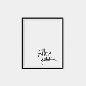 May include: Black framed print with the text "follow your" and a small heart drawn at the end of the line.
