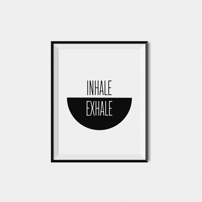 K&ouml;nnte beinhalten: Schwarz-wei&szlig; gerahmter Druck mit dem Text "INHALE EXHALE" in minimalistischem Stil.