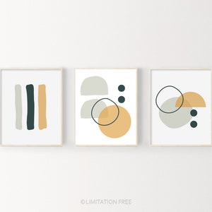 May include: Three minimalist abstract art prints with geometric shapes in shades of gray, yellow, and black. The prints are framed in a light wood frame.