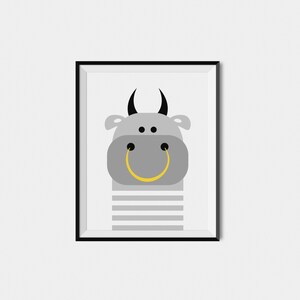 May include: A framed print of a gray cartoon bull with black horns and a yellow smiley face. The bull is wearing a gray and white striped shirt.
