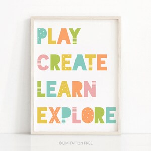 May include: A colorful printable wall art print with the words "PLAY CREATE LEARN EXPLORE" in a playful font. The words are in different colors, including yellow, green, blue, pink, and orange.