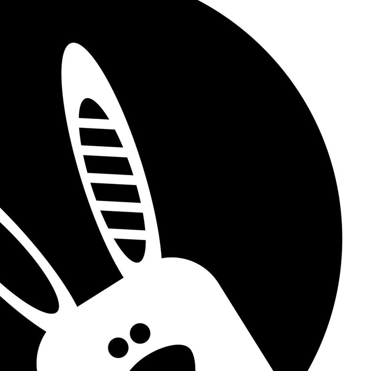 May include: Black and white illustration of a rabbit's head peeking out from behind a black circle.