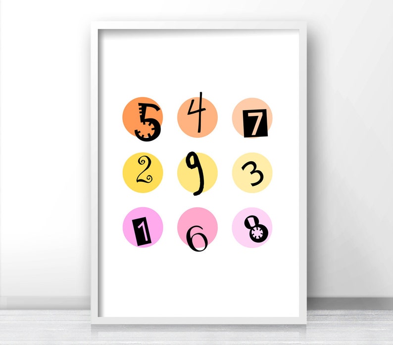May include: A white framed print with a colorful design of nine circles, each containing a number from 1 to 9. The circles are in three rows of three, with the numbers arranged in a random order. The circles are in shades of orange, yellow, and pink.