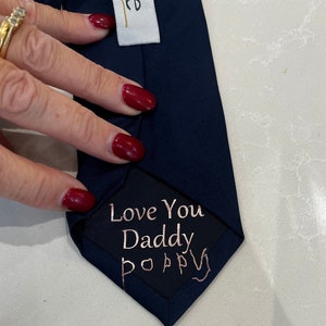 May include: A dark blue tie with a black patch that says "Love You Daddy Poppy" in gold lettering.