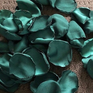 Op de afbeelding: Een stapel teal groene zijden rozenblaadjes. De blaadjes zijn zacht en delicaat, perfect om een ​​toets van elegantie toe te voegen aan elk evenement.