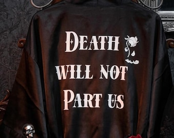 May include: Black satin robe featuring the phrase "Death Will Not Part Us" in white gothic font, with a skull and rose graphic. The robe is displayed on a dark wooden hanger.