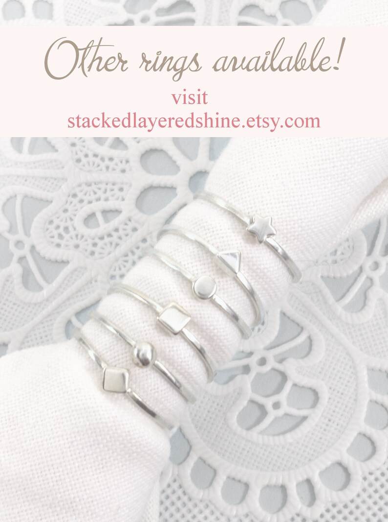 Puede incluir: Un conjunto de anillos apilables de plata con diferentes formas geom&eacute;tricas, incluyendo una estrella, un tri&aacute;ngulo, un c&iacute;rculo, un cuadrado y una cuenta. Los anillos se muestran sobre un fondo de tela blanca. &iexcl;Otros anillos disponibles! Visita stackedlayeredshine.etsy.com