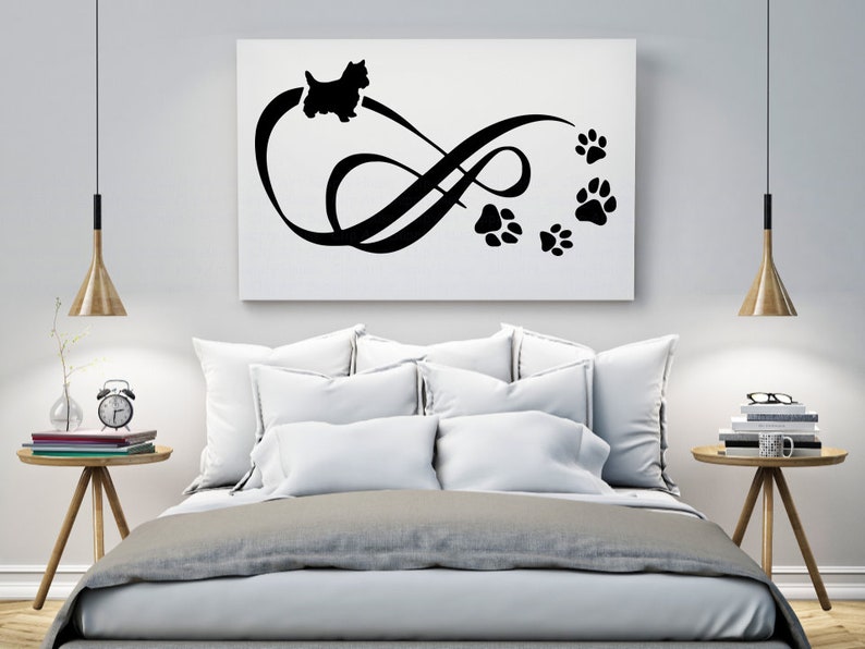 May include: Black and white silhouette of a dog with paw prints forming an infinity symbol on a white background. The image is displayed on a canvas and hung above a bed with white bedding.