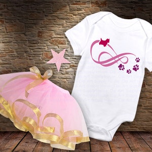 May include: A pink tulle tutu with a gold ribbon trim and a white onesie with a pink and purple infinity symbol with a dog silhouette and paw prints.