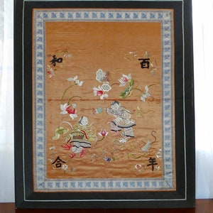 Può includere: Ricamo antico su seta incorniciato con una scena con figure e motivi floreali nei toni dell'oro, del rosso e del verde. L'opera d'arte include caratteri cinesi ed è racchiusa in una cornice di legno nera con un bordo decorativo.