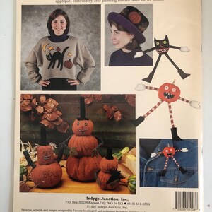 May include: A book cover featuring Halloween-themed sewing patterns. The cover includes images of a woman wearing a sweater with a black cat and a hat with a basketball design. There are also images of pumpkin-shaped dolls and the text "Humble Spirits".