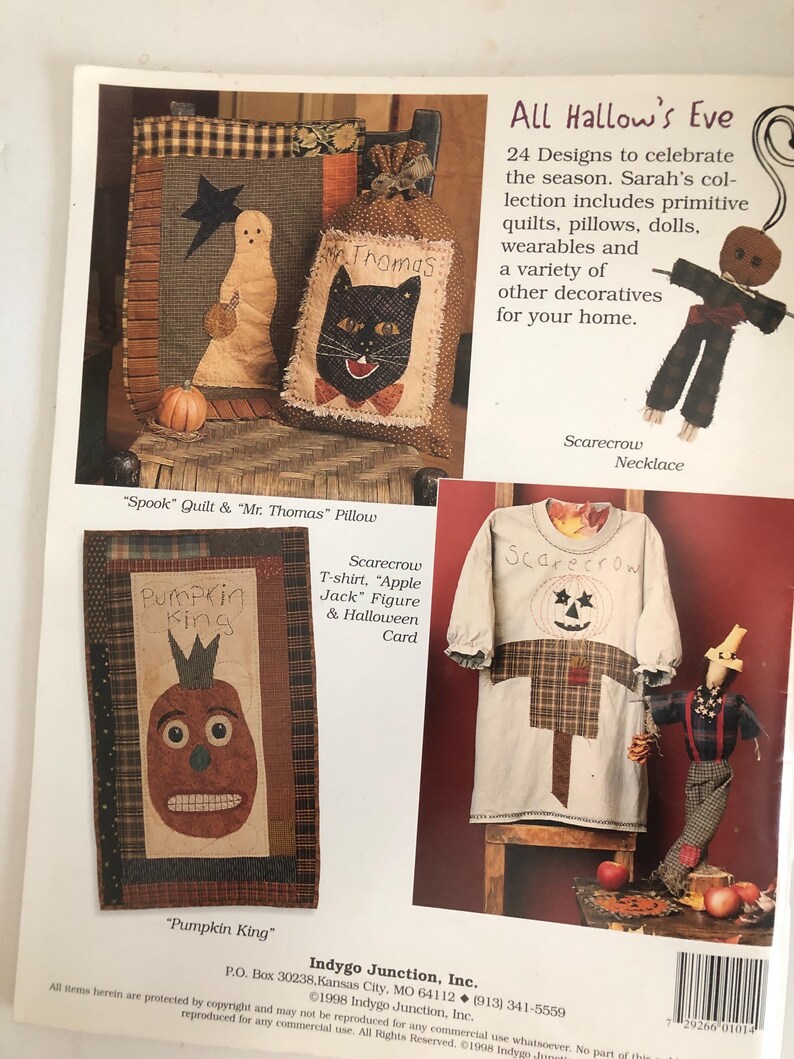 May include: A page from a craft book featuring Halloween-themed designs. It includes images of a ghost quilt, a cat pillow, a pumpkin-faced wall hanging, and a scarecrow t-shirt. The text reads "All Hallow's Eve" and "Pumpkin King."