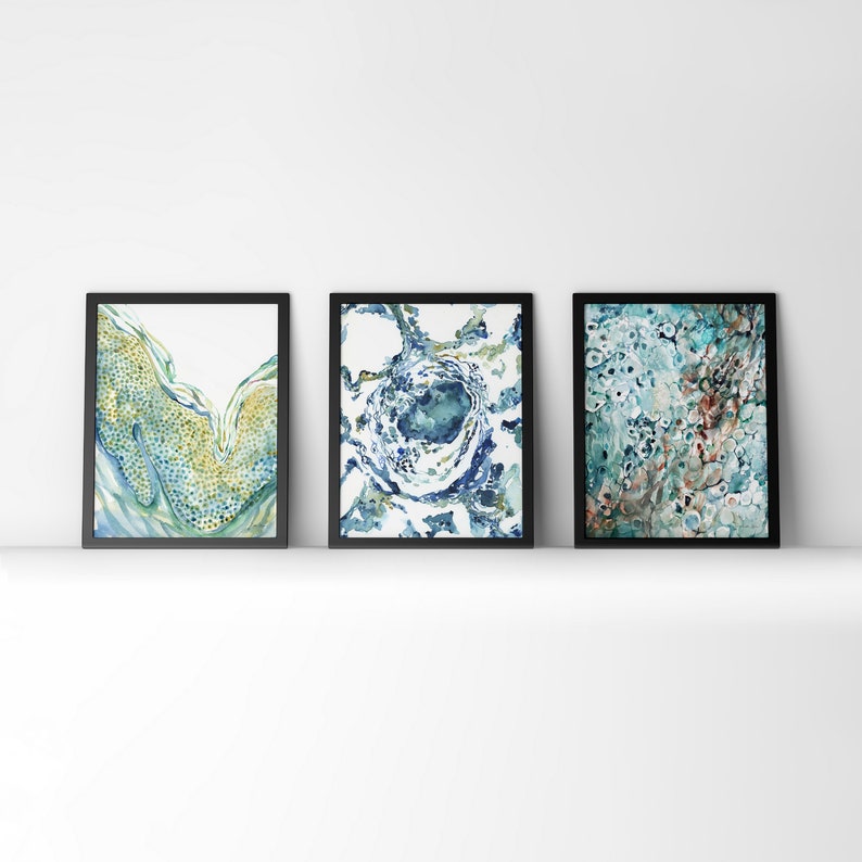 May include: Three framed abstract watercolor paintings with blue, green, and white colors. The paintings have a swirling, organic pattern.