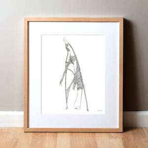 May include: A black and white line drawing of a person in a dress, framed in a light wood frame.