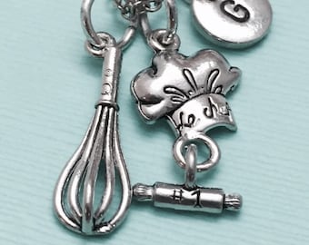 May include: Silver necklace with charms including a chef's hat, a rolling pin, a whisk, and a letter G charm.