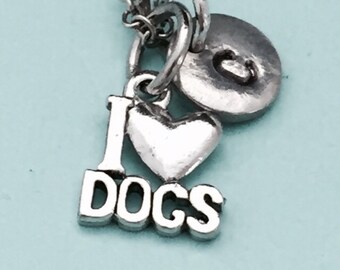 May include: Silver necklace with a heart charm that says "I love dogs" and a round charm with the letter "C".