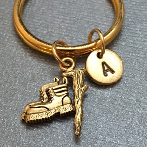 May include: Gold keychain with a boot, a stick, and a charm with the letter A.
