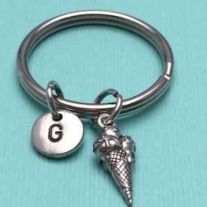 May include: Silver keychain with a letter G charm and a small ice cream cone charm.