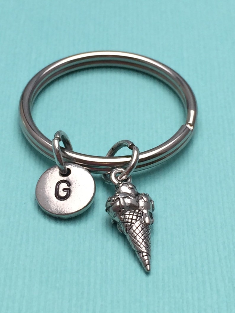 May include: Silver keychain with a letter G charm and a small ice cream cone charm.