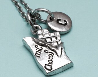 May include: A silver necklace with a charm that says "Mi Choco" and a silver charm with the letter "C".