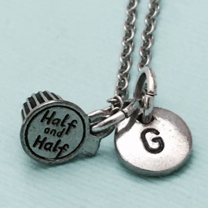 May include: Silver necklace with a charm that says "Half and Half" and a charm with the letter "G".