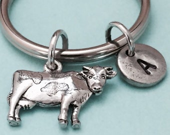 May include: Silver cow keychain with a silver charm with the letter A on a silver key ring.