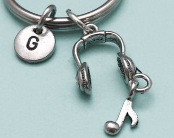 Puede incluir: Llavero con un dije de plata con la letra G, un par de auriculares y una nota musical.