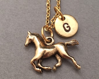 May include: Gold necklace featuring a horse charm and a gold initial charm with the letter G.