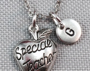 Op de afbeelding: Zilveren ketting met een bedel in de vorm van een appel met de woorden "Special Teacher" en een letter "G" bedel.